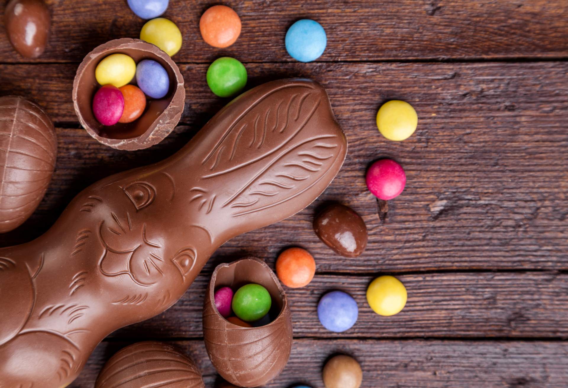 Chocolate easter eggs and sweets on wooden background