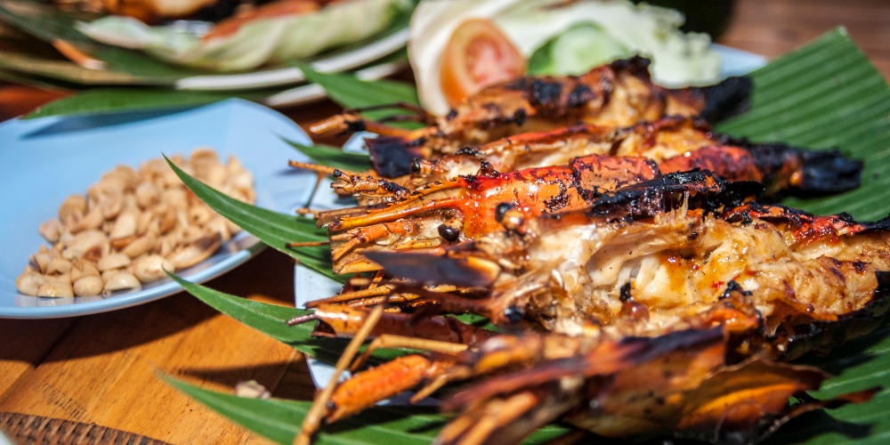 Grilled lobster on the shell sitting on a banana leaf.