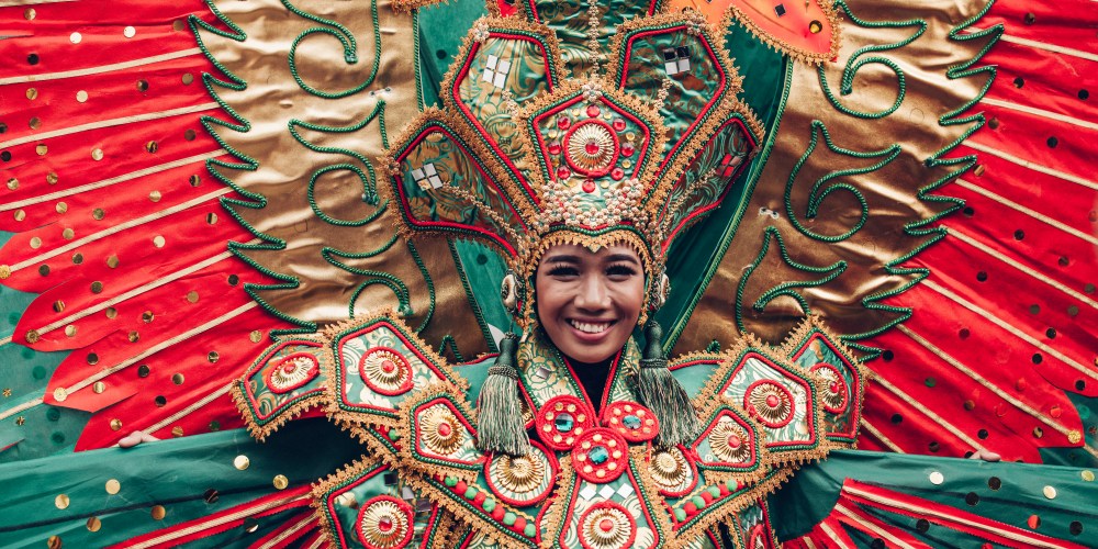 Asian woman in traditional Indonesian costume of Garuda performing ritual dancing ceremony smiling