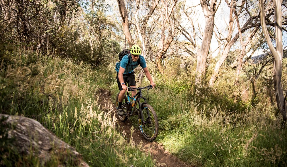 A man rides his mountain bike through different areas of Mount Kosciuszko National Park, in New South Wales, Australia