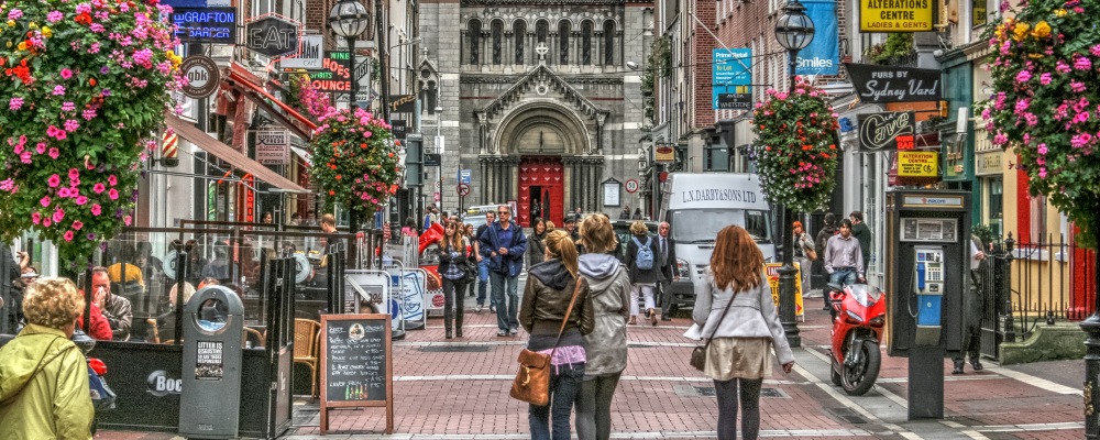 Famous shopping area in Dublin, Ireland.  Grafton Street showing shoppers, shops and church.