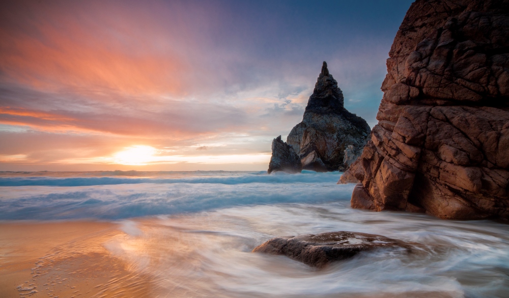 Sunset sky over the fine sand of Praia da Ursa beach, Cabo da Roca, Colares, Sintra, Portugal