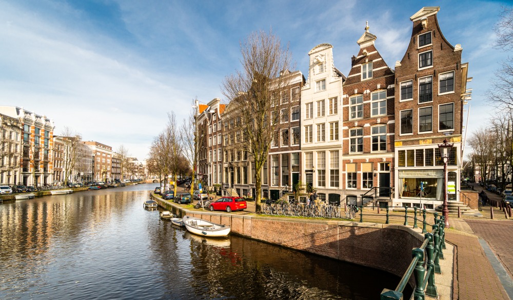 Traditional Dutch houses by the famous canals of Amsterdam historic city center in the Netherlands on a sunny winter day