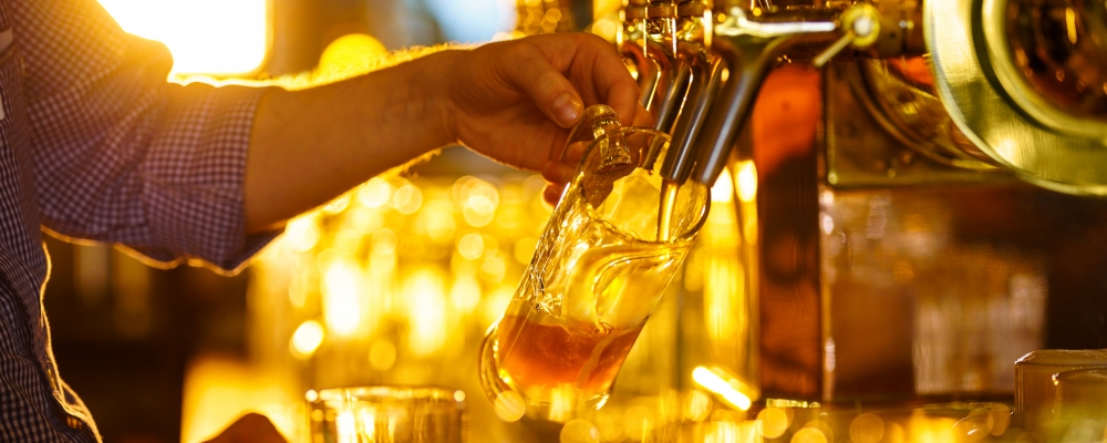 Male hands poured beer from the tap