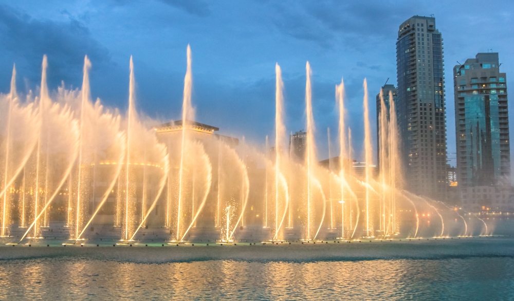 Night view of the light show at Dubai Dancing Fountain. The Dubai Fountain, the world largest choreographed fountain on Burj Khalifa Lake area, performs to the beat of the selected music.