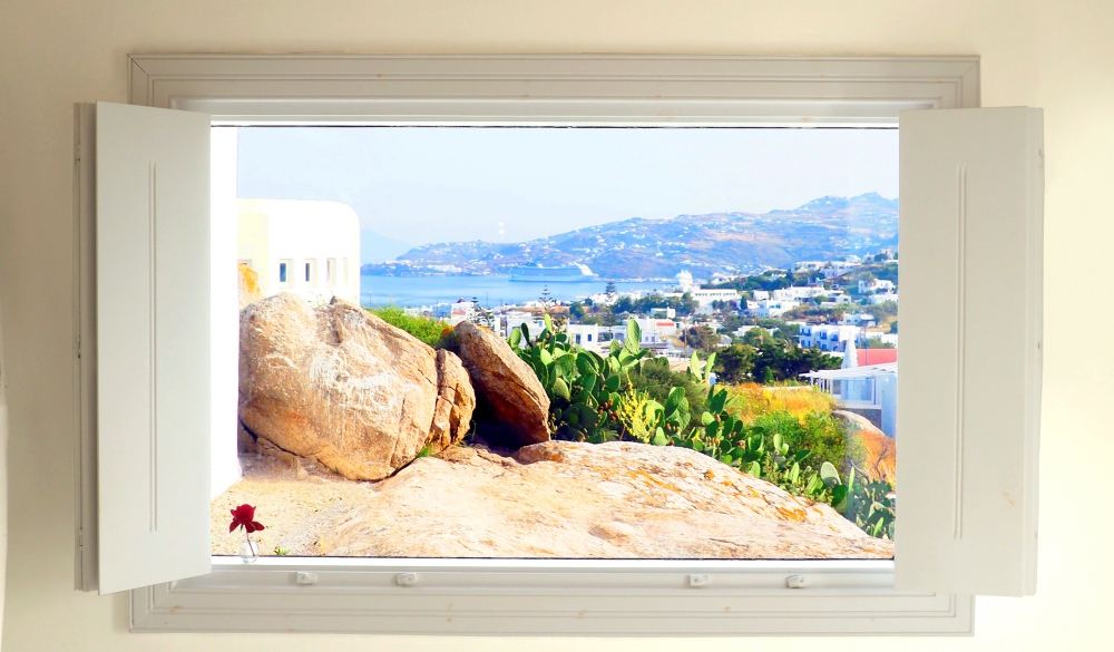 Magical white window offering a beautiful view of the island of Mykonos