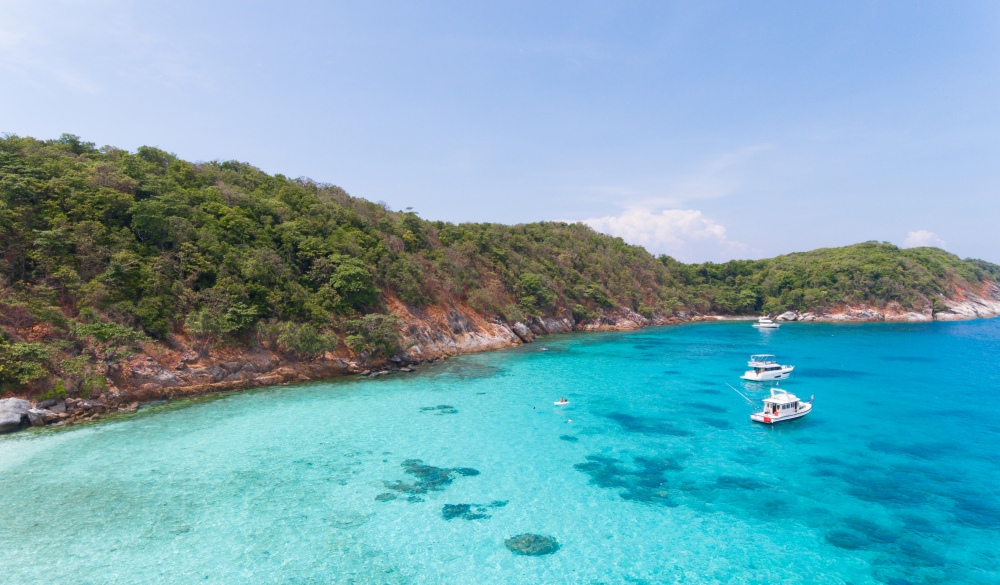 Blue water and Motor recreation boats on the tropical beach in the Racha Noi island Thailand