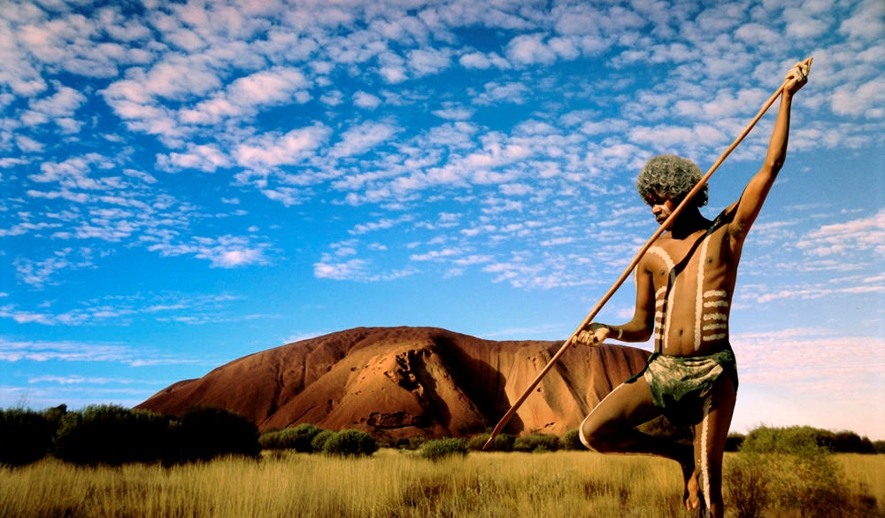 Aboriginal hunter in outback at sunset.