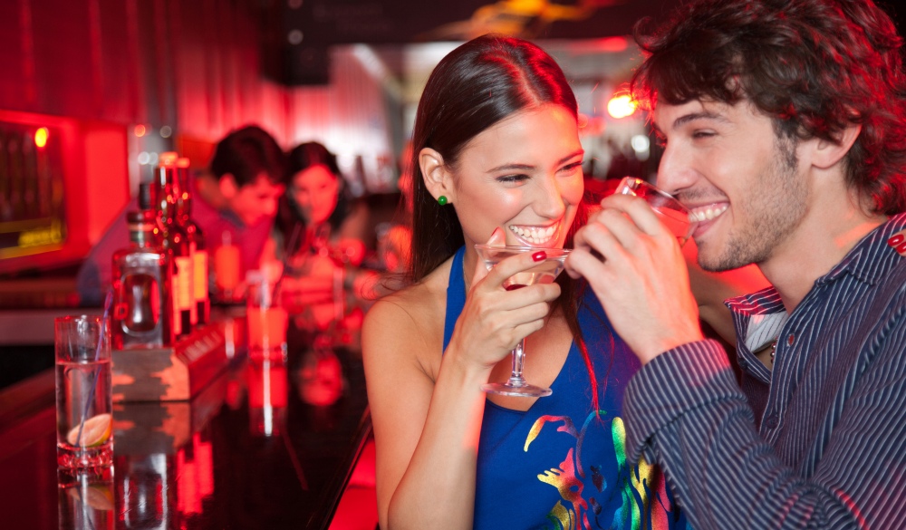 Smiling couple in nightclub with beverage, Quezon City nightlife spots