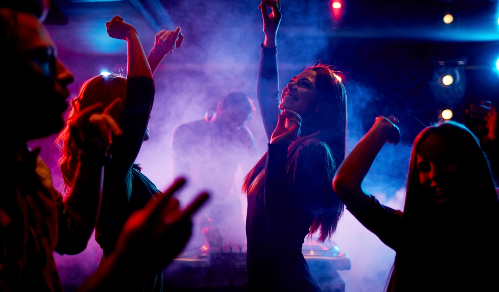 Group of dancing young people enjoying night in club, Quezon city nightlife spots