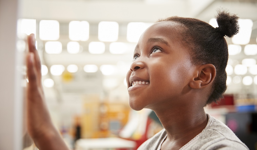 Young black girl looking at a science exhibit, close up