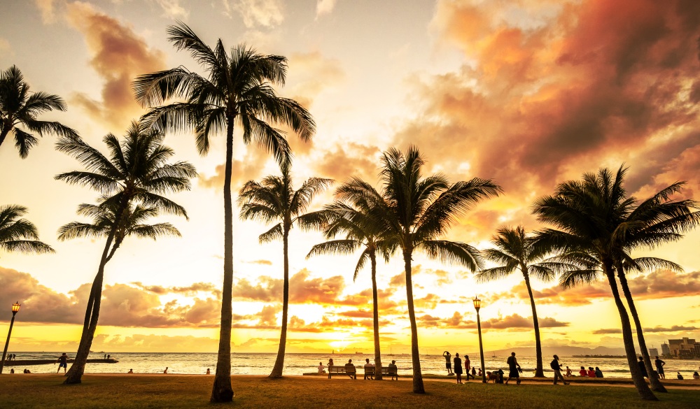 Typical picturesque sunset along Waikiki Beach with hundreds gathering to watch