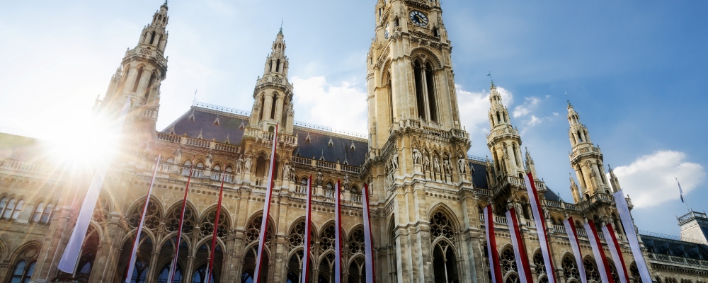 The Wiener Rathaus (Vienna City Hall, Austria) at sunset, with austrian flags over the facade