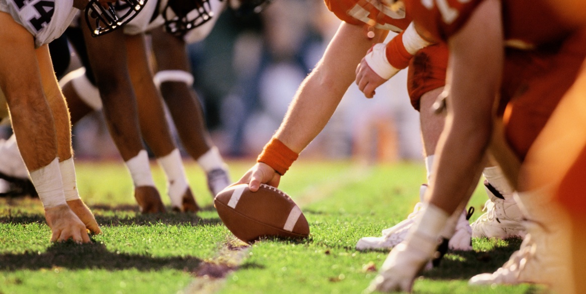 American football game, players at line of scrimmage, close-up