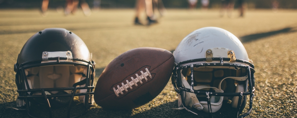 American football helmets and ball on the playing field.