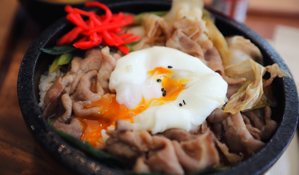 Japanese food Gyudon Japanese beef on rice bowl topped with egg on wooden table