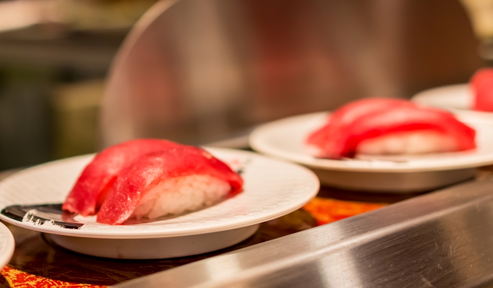 Delicious Japanese rotating sushi close up view in Tsukiji, Tokyo, Japan.