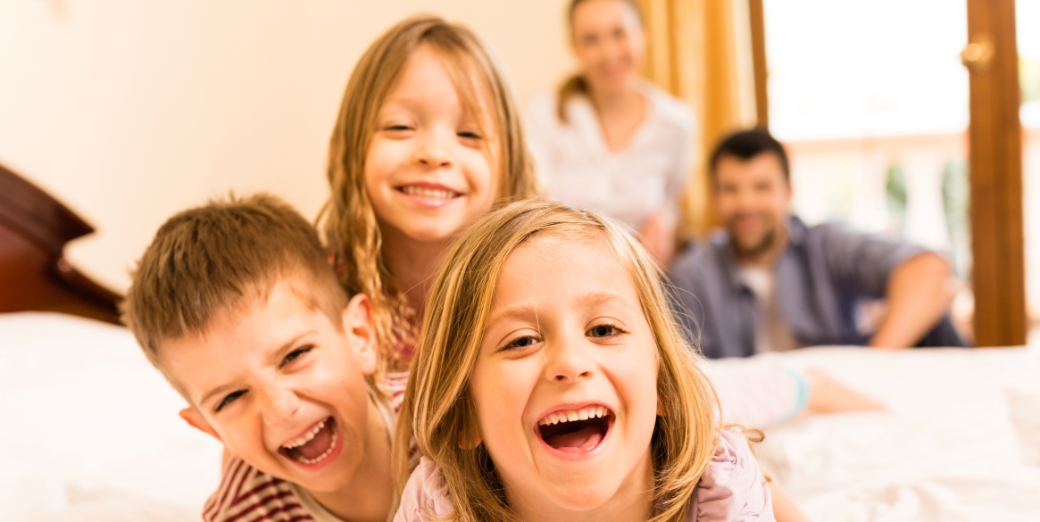 Happy children and their parents in the background.