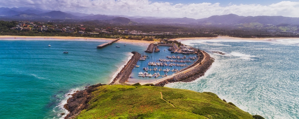 Coffs harbour town waterfront from Muttonbird island connected to shore by stone wave breaking wall protectin marina and local sandy beach.; Shutterstock ID 1245779353
