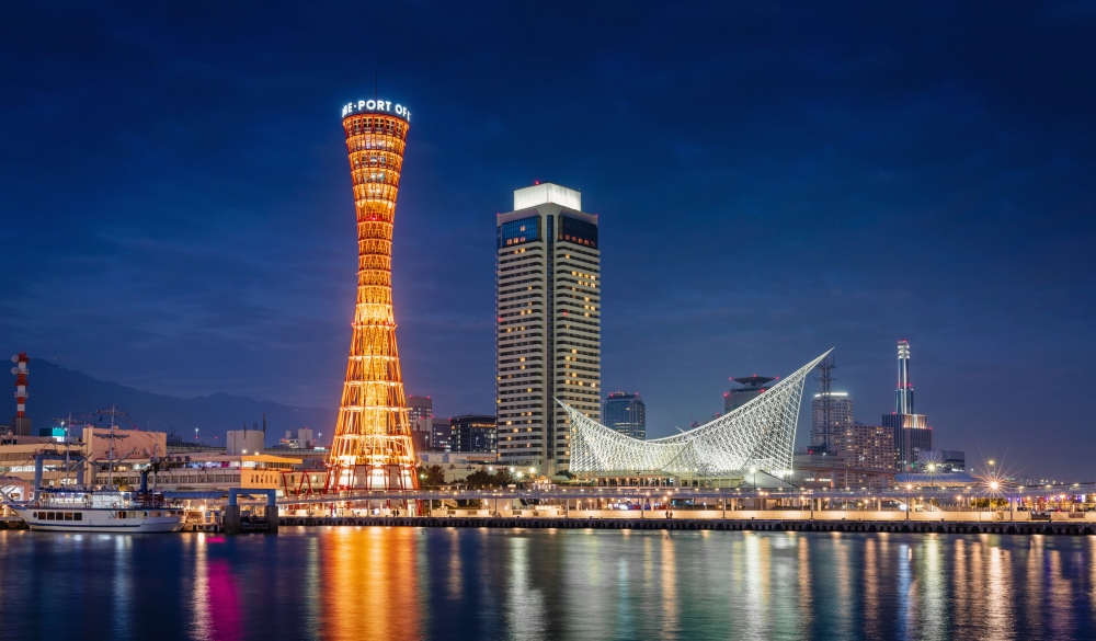 Beautiful illuminated Kobe Port Waterfront Refelections and Harbour Cityscape with orange illuminated Kobe Port Tower at Night after Sunset. Kobe, Honshu, Japan, Asia