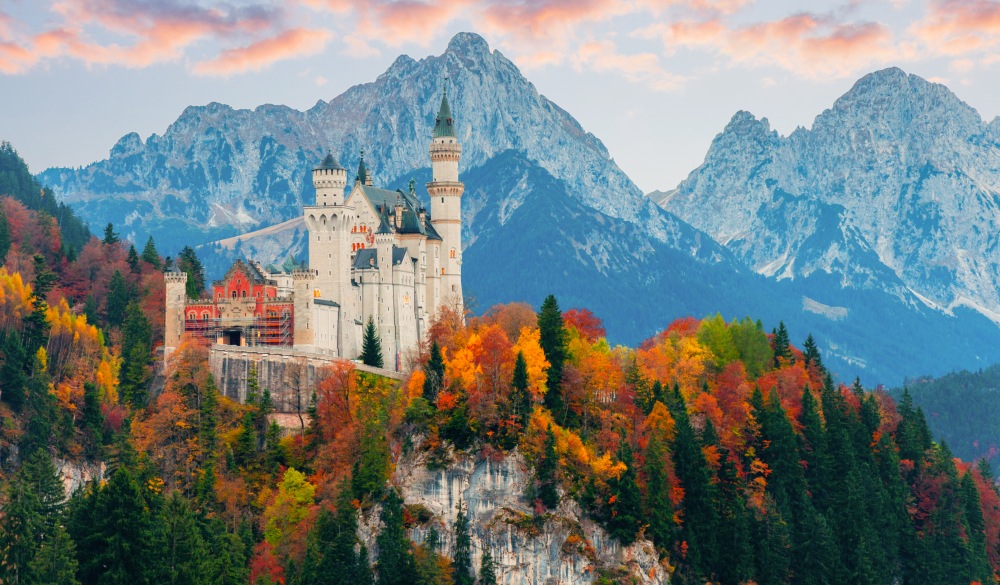 Picturesque autumn view on Neuschwanstein Castle with colorful trees and the Alps on background, Bavaria, Germany. Beautiful autumn colorful scenery.;