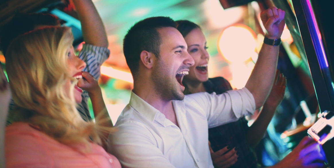 Group of young adults in mid 20's playing slots in a casino