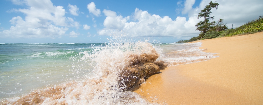 Ondas batendo na praia em Kauai, Havaí. Praia Kapaa.