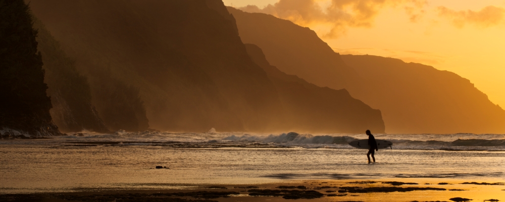  Surfeur sur la plage et la côte de Na Pali vue depuis la plage de Ke'e, Ha'ena 