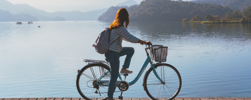 Young woman riding bicycle on Sun Moon lake bike trail, Travel lifestyle concept