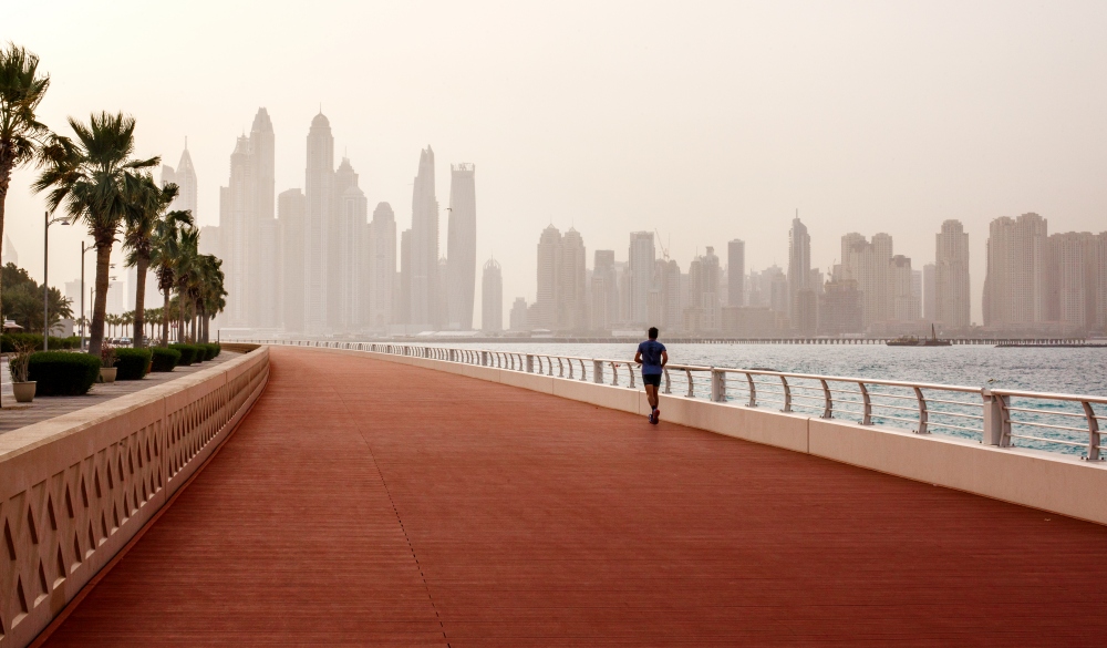 Morning run, a man runs along the road, Dubai on a budget