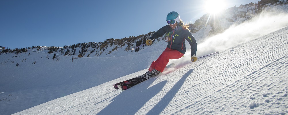 A woman skiing on a sunny winter day at Snowbird