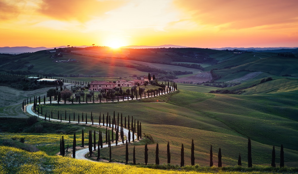 Tuscany landscape with winding country road at sunset