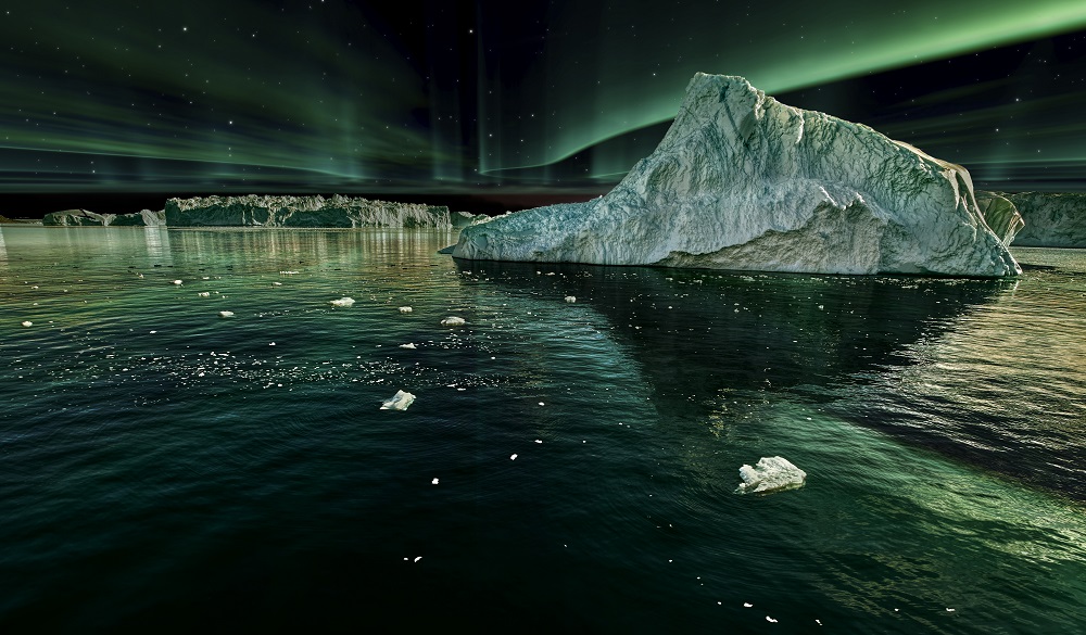 iceberg floating in greenland fjord at night with green northern lights.