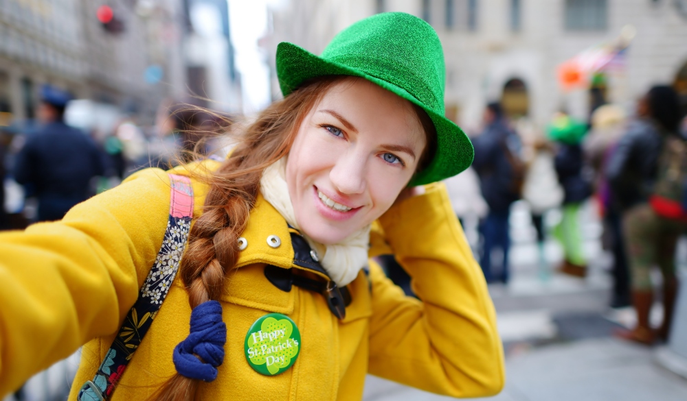 Young tourist taking a selfie with her smartphone during the annual St. Patrick's Day Parade on 5th Avenue in New York City