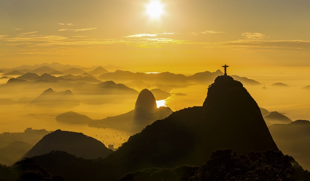 Panoramic view at sunrise in Rio de Janeiro with Christ the Redeemer, Sugar Loaf,  Botafogo Bay and Guanabara Bay. City of Niterói in the background.