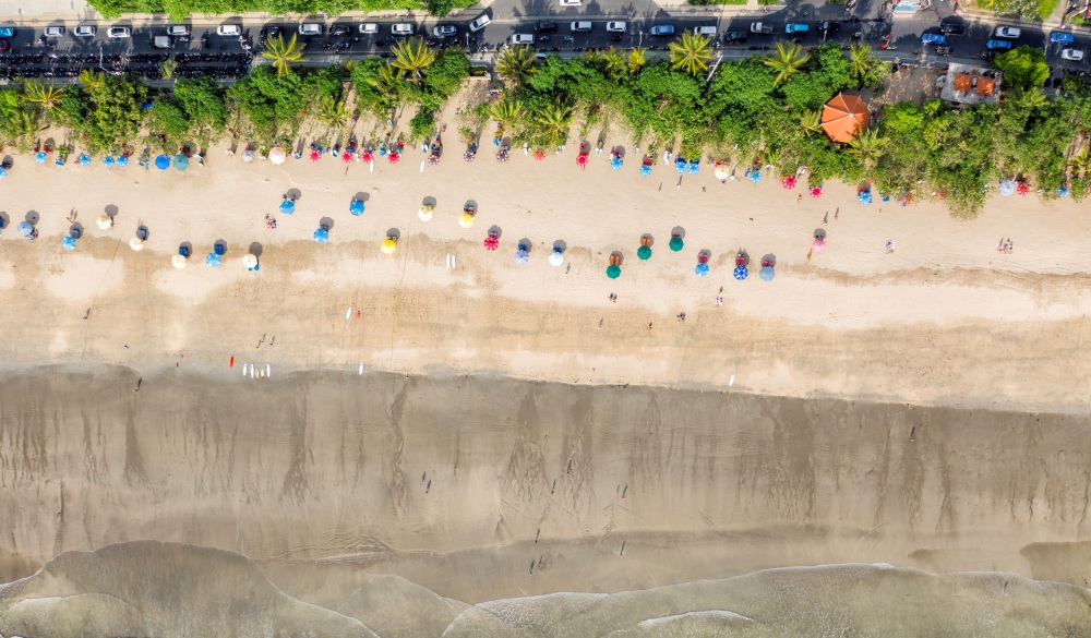 Top aerial view of color umbrellas on the Kuta beach, Bali