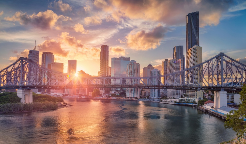 Cityscape image of Brisbane skyline, Australia with Story Bridge during dramatic sunset.