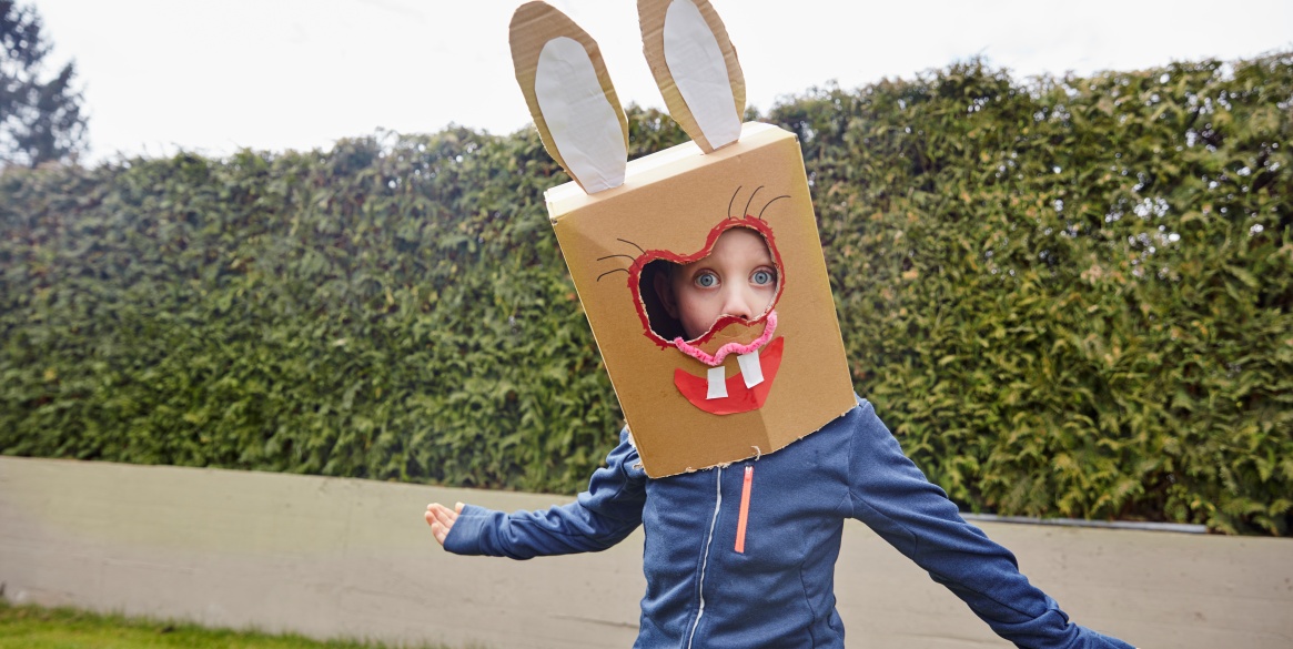Boy wearing bunny mask in garden, spring break destinations