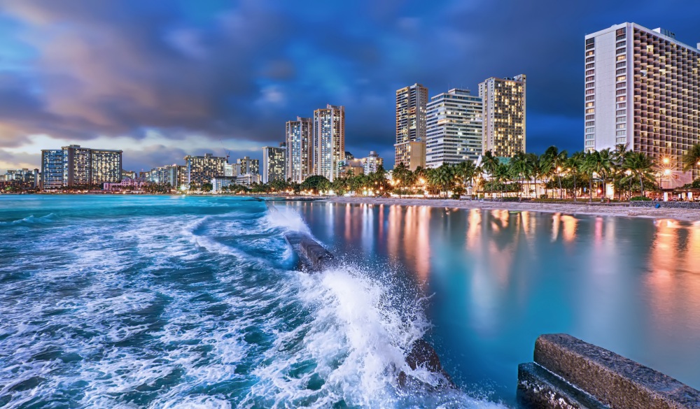 Waves surge towards Waikiki's beaches in the blue hour.