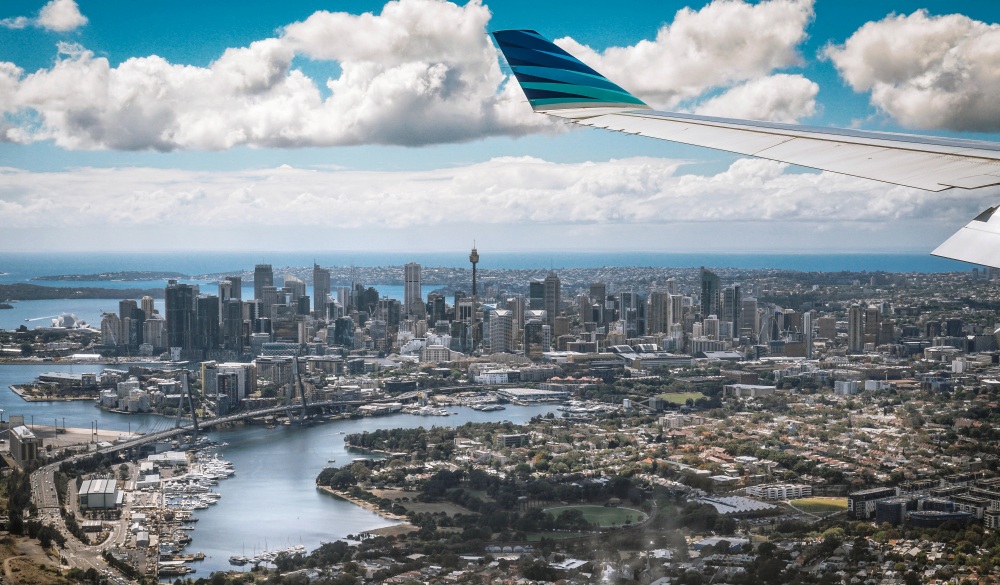 Cropped Wing Airplane Flying Above City