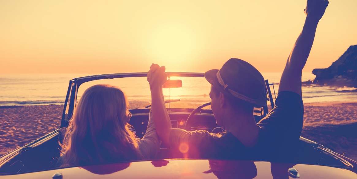 Couple watching the sunset in a convertible car