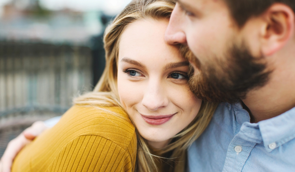 Close up of romantic young couple on city rooftop terrace