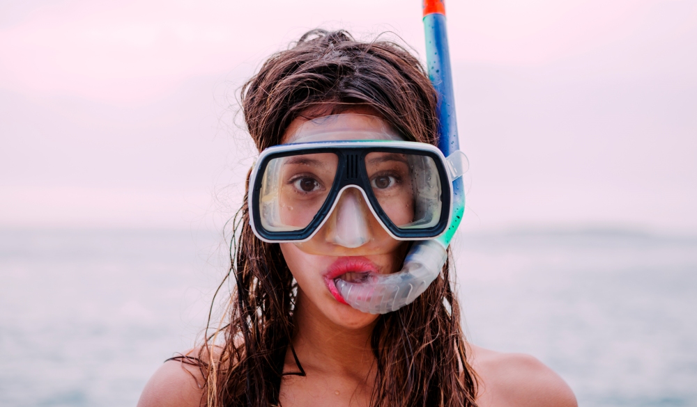 Young woman with diving goggles and snorkel