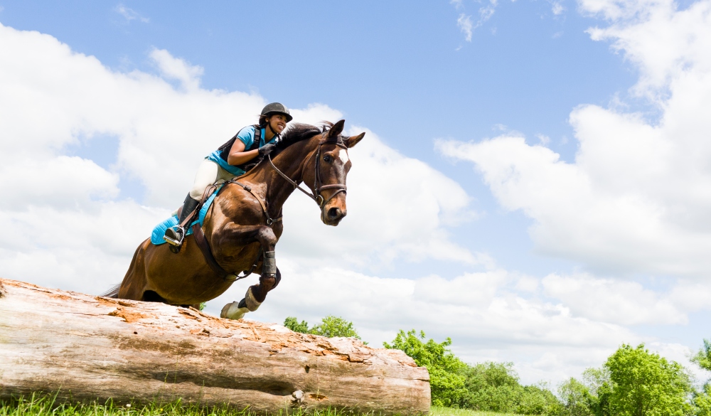 Young Black Women riding a horse, small-town LGBT U.S> destinations