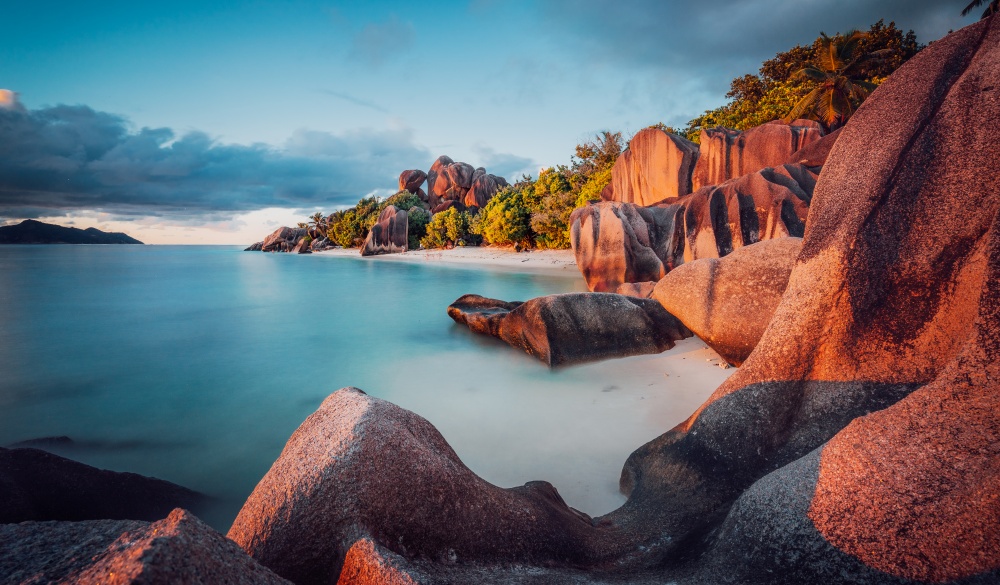 boulders and a dramatic sunset at Anse Source d'Argent beach, La Digue island, tropical island vacations