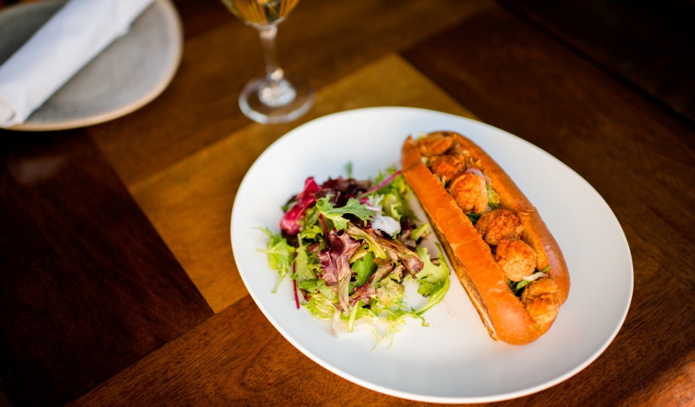 Plate of fried shrimp poboy sandwich on restaurant table