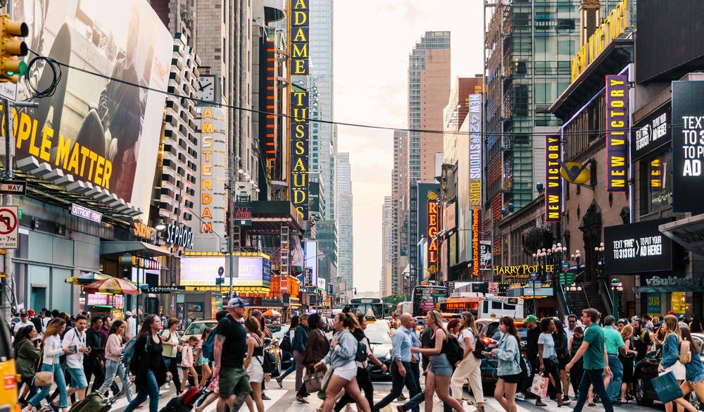 Crowds of people crossing street on zebra crossing in New York, USA