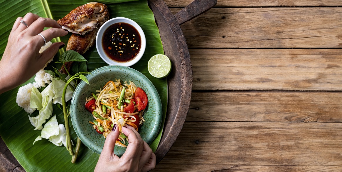 fresh world famous Som Tam (papaya salad) with BBQ chicken, sticky rice and raw salad vegetables