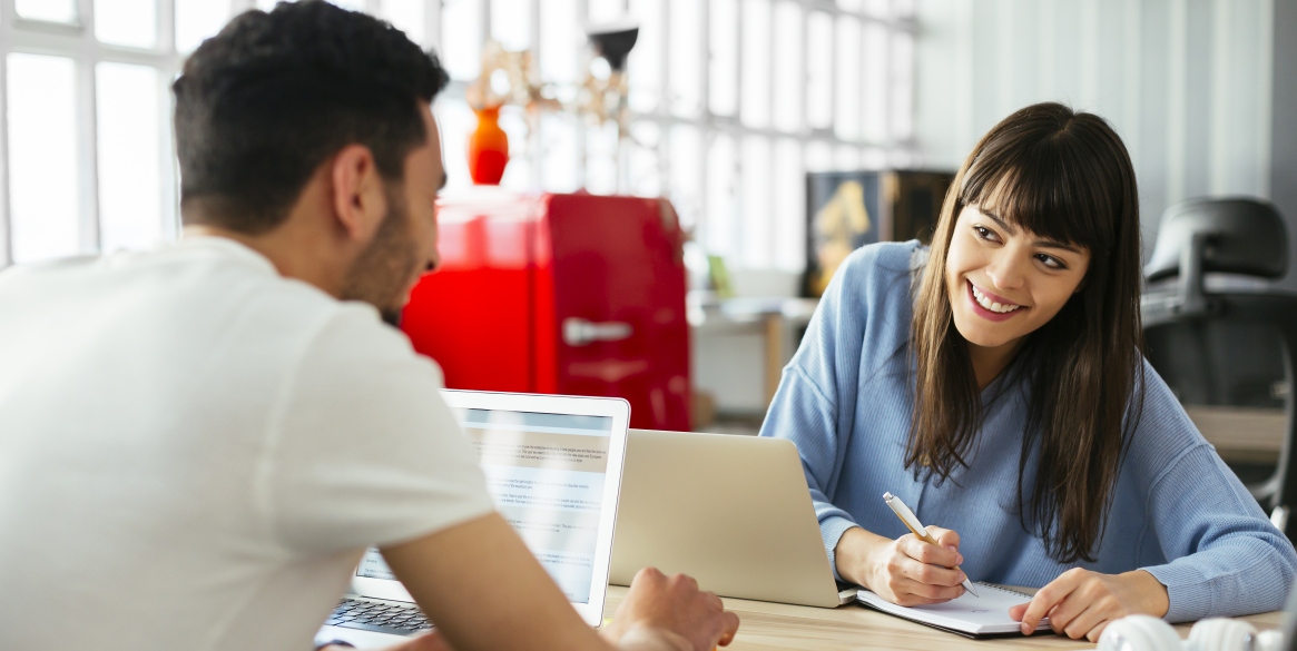 Smiling colleagues working at desk in office