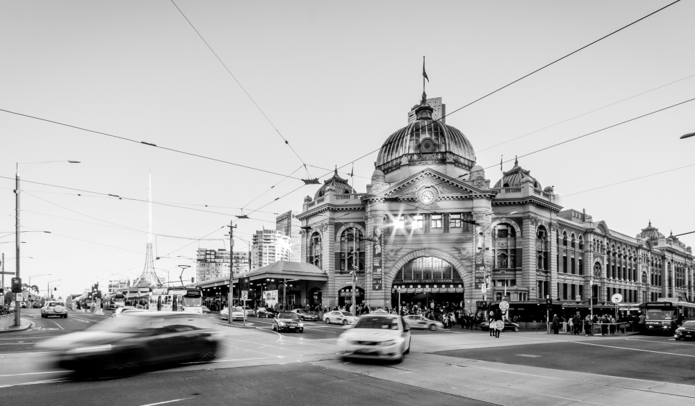 Long Exposure of a car in front of iconic Flinders Street Station in Melbourne, Australia. Arts Centre is also visible in the background.